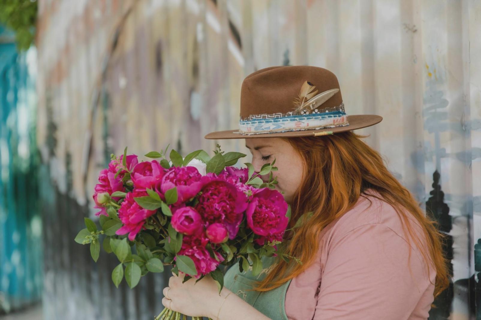 Detailansicht einer floralen Tischdekoration mit Kerzen und saisonalen Blüten