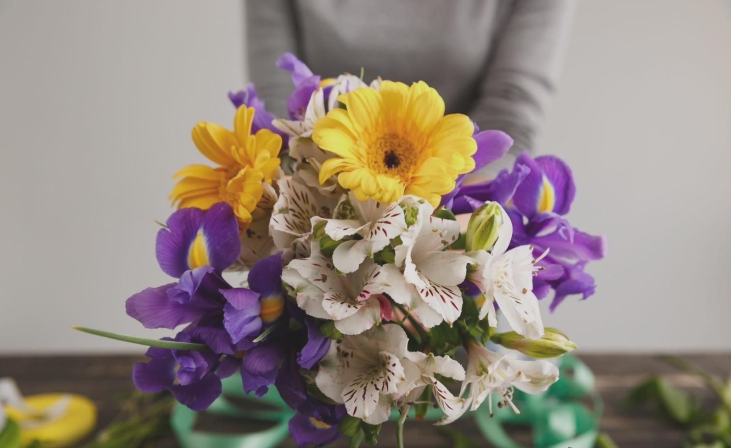 Arbeitsfläche mit Floristen-Werkzeugen und frischen Blumen während eines Workshops